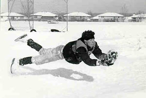 Stretching out for a football in the snow